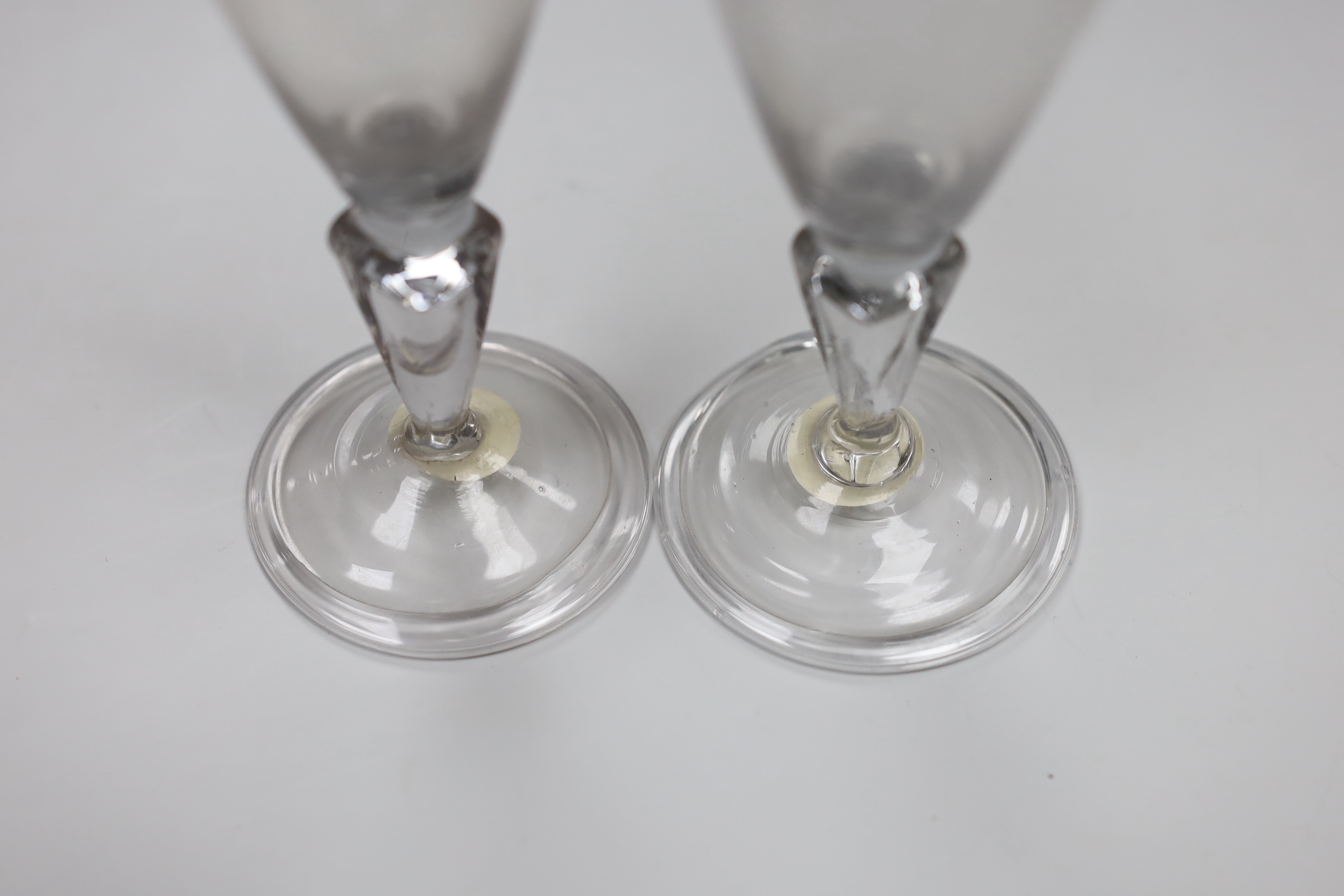 A pair of Continental facon de Venice wine glasses, first half 18th century, round funnel bowls and hollow moulded pedestal stems, folded feet, tallest 13.5cm